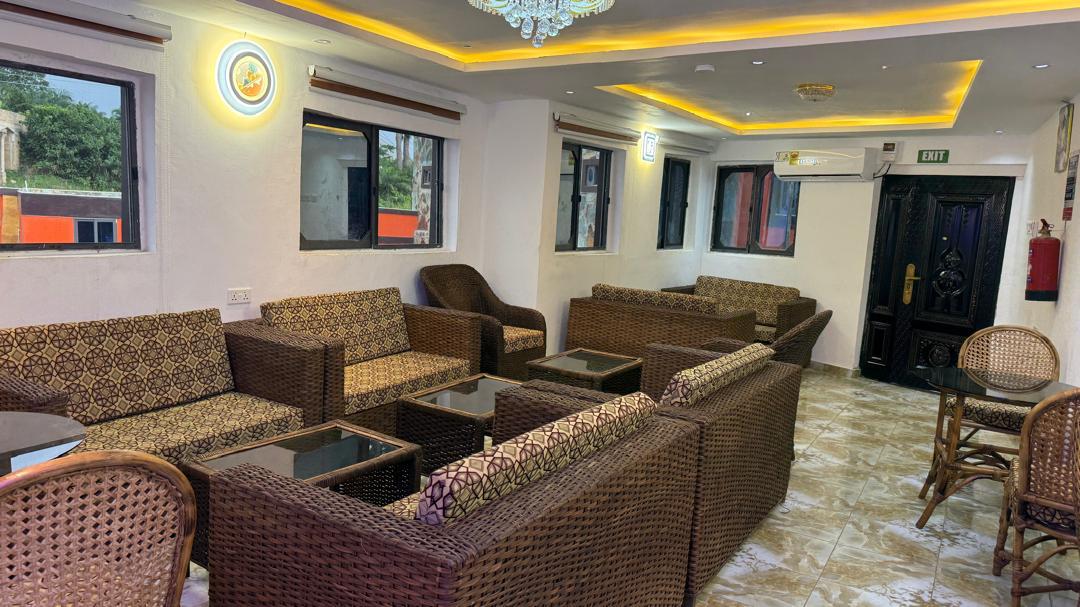 Conference space with woven armchairs, tables and large windows.